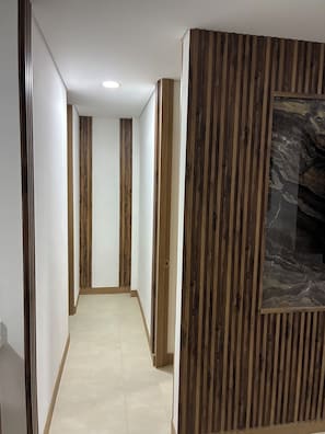 Een gang met houten lambrisering en een marmeren muur.
