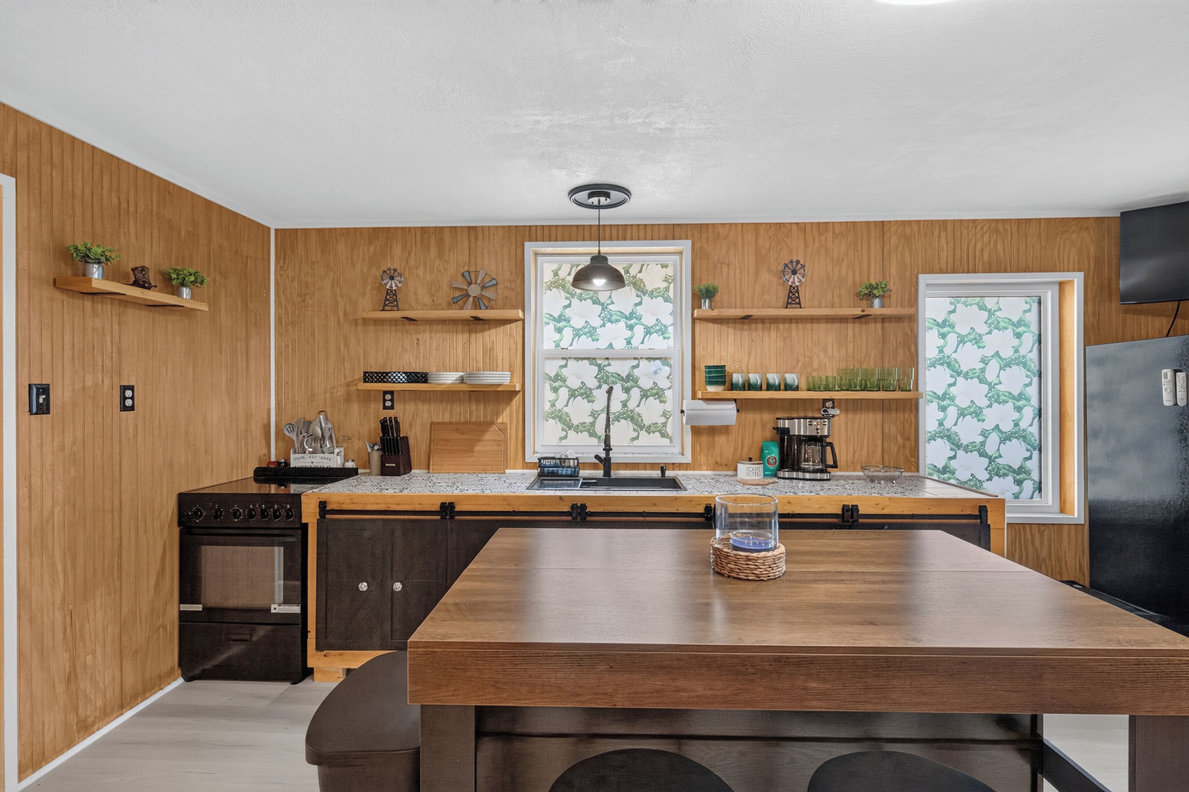 A modern kitchen with wooden cabinetry, a central island, and decorative items.