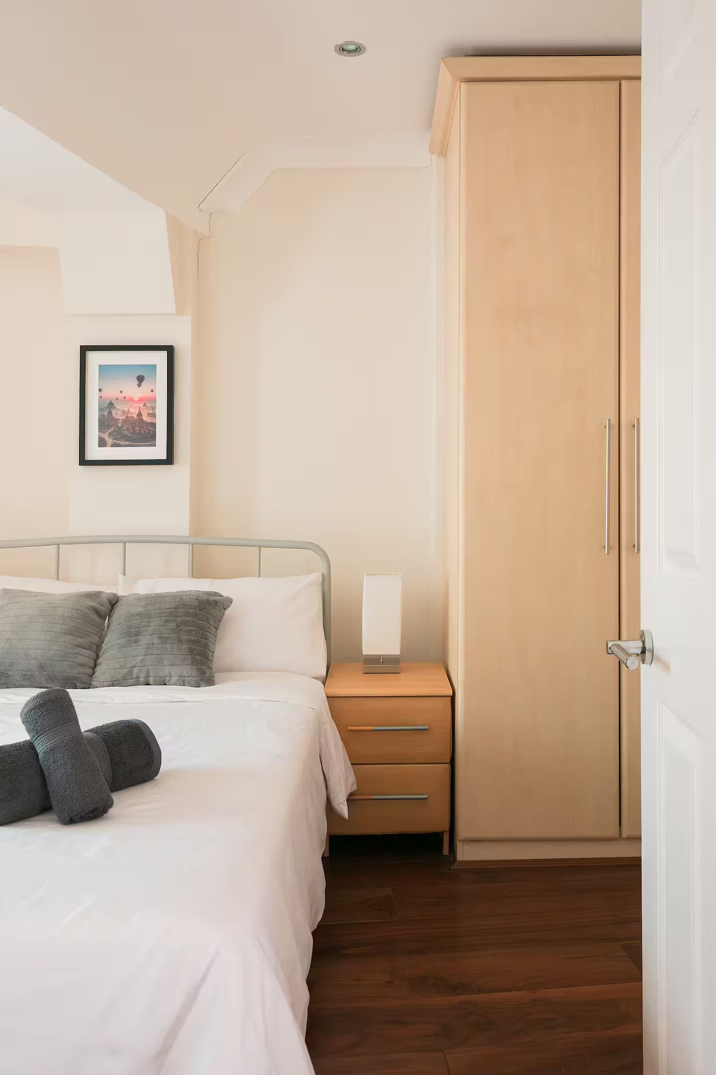 A bedroom with a bed, bedside table, lamp, and a wardrobe. - Entire Westminster Townhouse Near WestminsterAbbey (London)