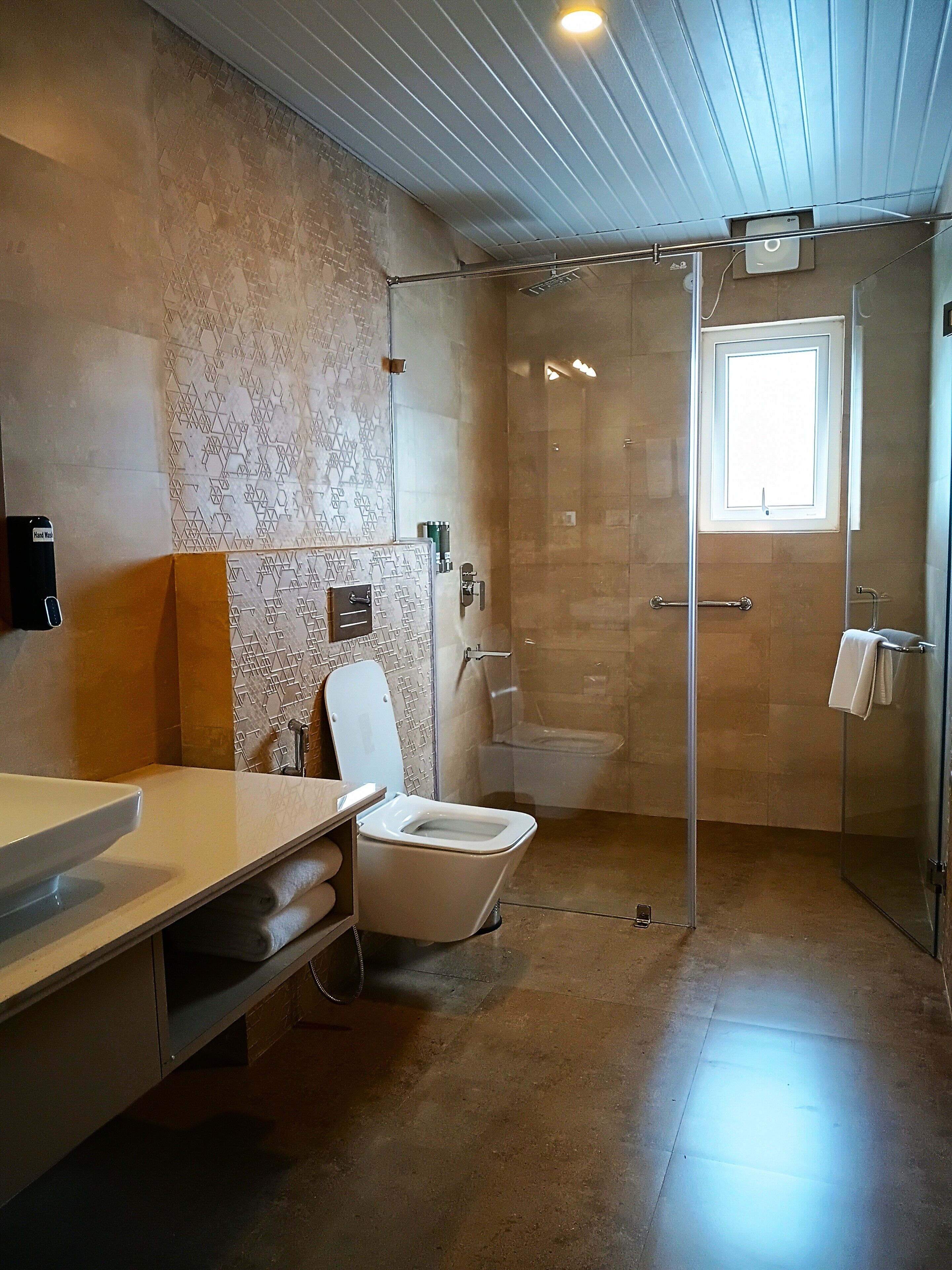 A modern bathroom with a toilet, sink, and shower area.