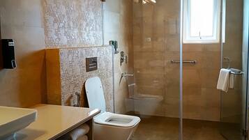 A modern bathroom with a toilet, sink, and shower area.