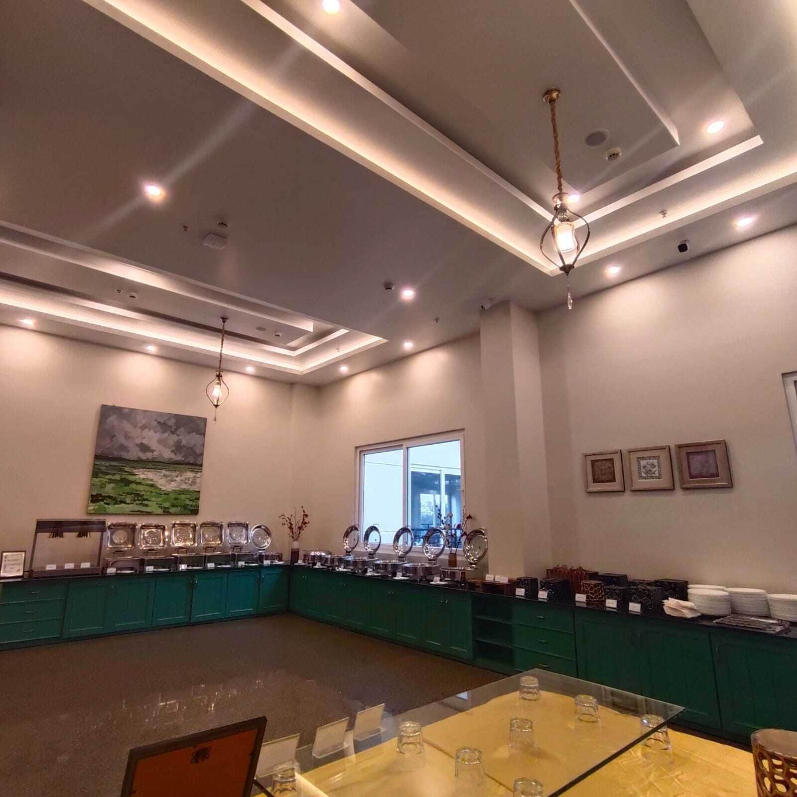 Una sala de conferencias con una mesa de vidrio, sillas, un cuadro en la pared y un ventanal.
