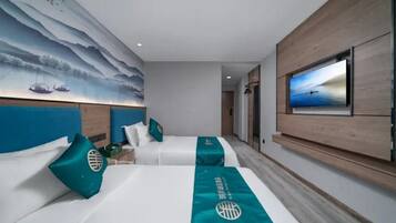A hotel room with two beds, a large painting on the wall, a television, and a view of the sea.