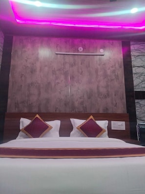 Habitación de hotel con cama, cabecera de madera y lámpara de pared.
