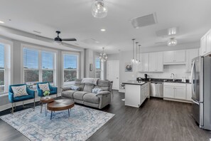 A modern kitchen with white cabinets, stainless steel appliances, and a central island.