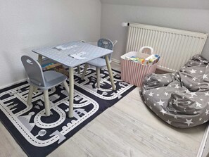 A child's play area with a table, chairs, a bean bag, and a storage box. - Modern, child-friendly vacation rental not far from the North Sea (Langenhorn)