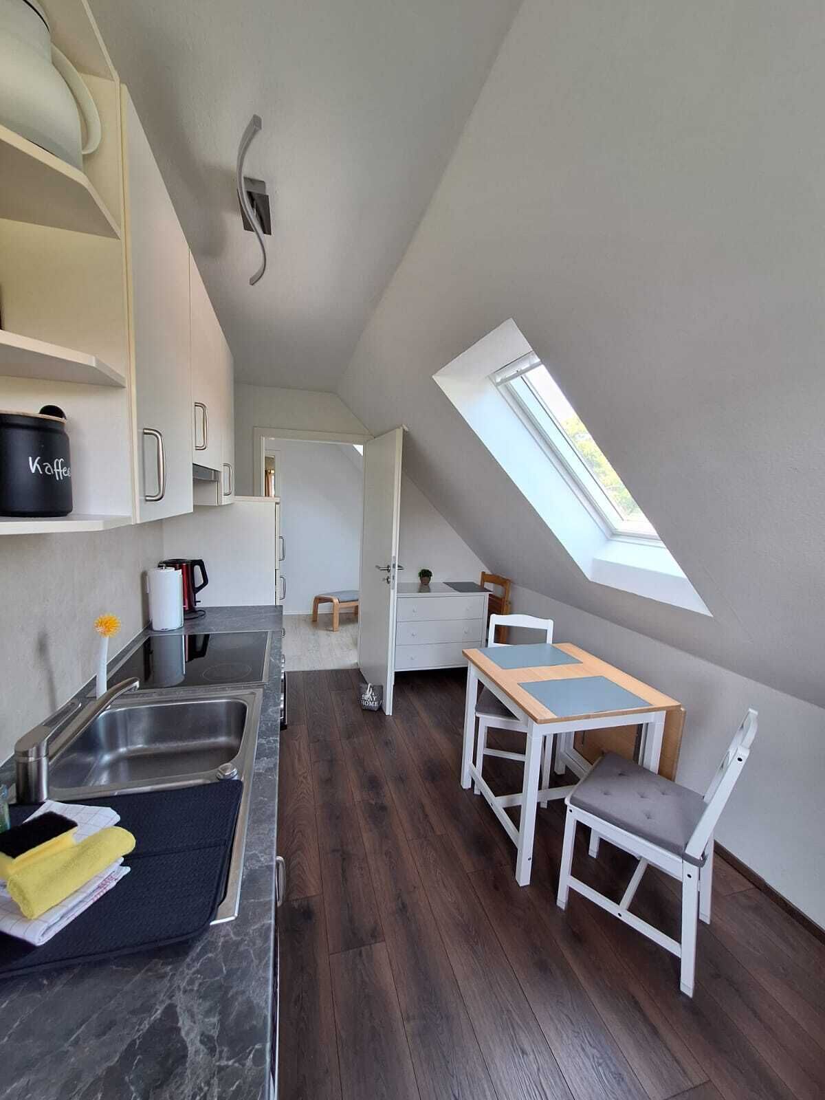 A compact kitchen with a skylight, a dining area with a table and chairs, and a small kitchenette.