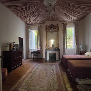 A room with a fireplace, a bed, a desk with a chair, a dresser, and a large mirror. - Superb 4-bedroom Chateau in a private setting of 4 hectares of woodland. (Coutras)