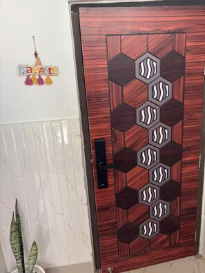 Una puerta de madera con un diseño geométrico y un ojo de cerradura.