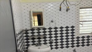 A bathroom with a white sink, a mirror, a shower, and a toilet.