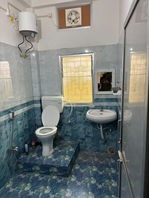 Een badkamer met toilet, wastafel en douche.