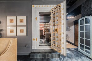 A hallway with a large, ornate door, framed artwork, and a bar area visible through the door. - Historic Loft, Downtown Knoxville, Market Square (Knoxville)