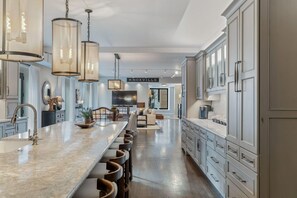 A spacious kitchen with a long island, bar stools, and a large cabinet area. - Historic Loft, Downtown Knoxville, Market Square (Knoxville)