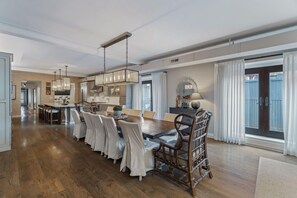A spacious dining area with a long wooden table, multiple chairs, and a hanging light fixture. - Historic Loft, Downtown Knoxville, Market Square (Knoxville)