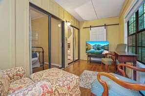 Un salon comprenant un canapé, un téléviseur et un coin repas avec une table et des chaises.