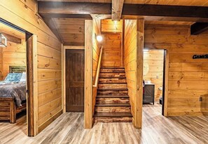 Eine Holztreppe führt zu einem Schlafzimmer mit einem Bett und einem Nachttisch.