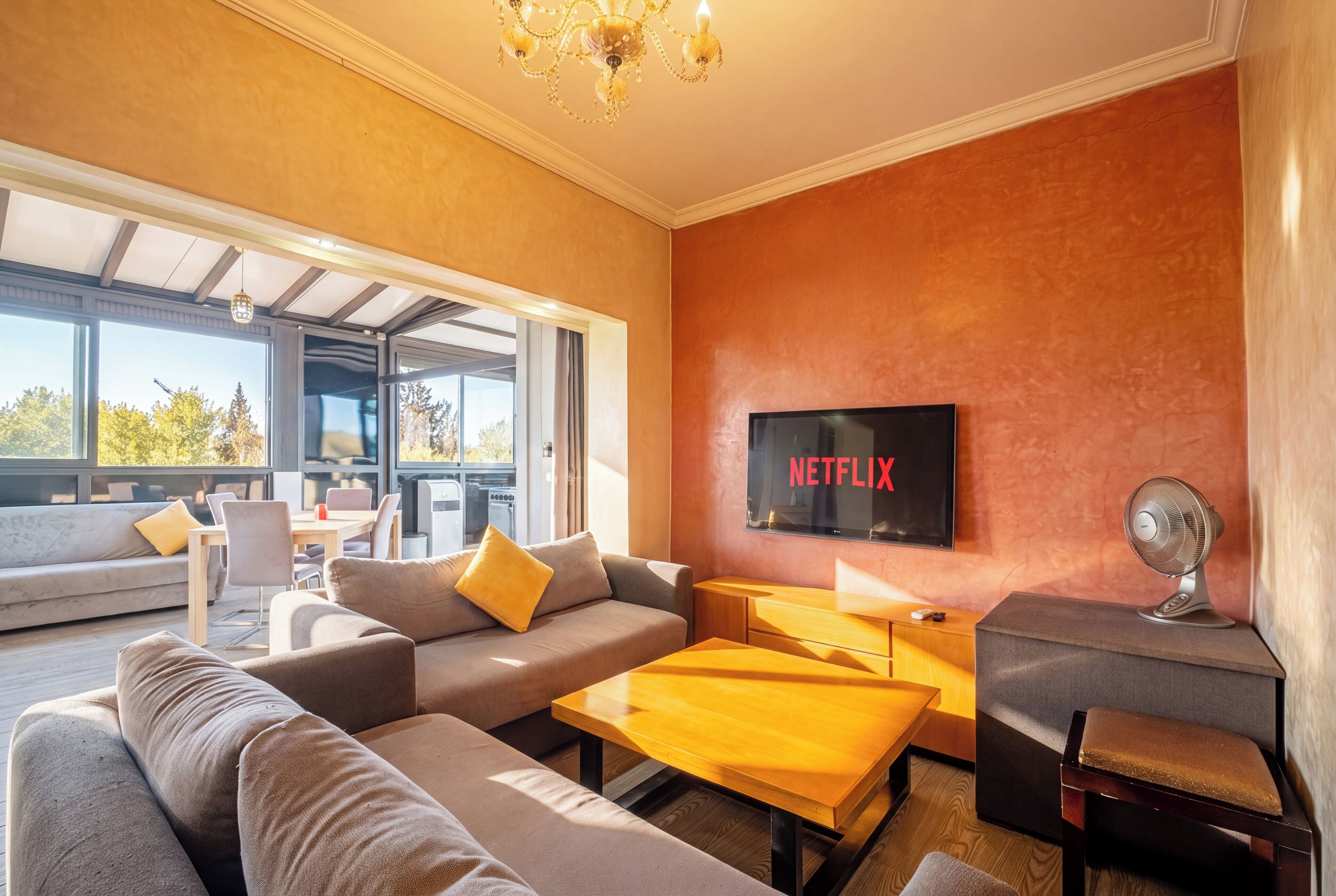 Un salon moderne avec un canapé, une table basse et un téléviseur à écran plat fixé au mur.