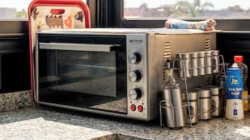 Una cucina con forno tostatutto, pentole in acciaio inossidabile e una bottiglia d'acqua.
