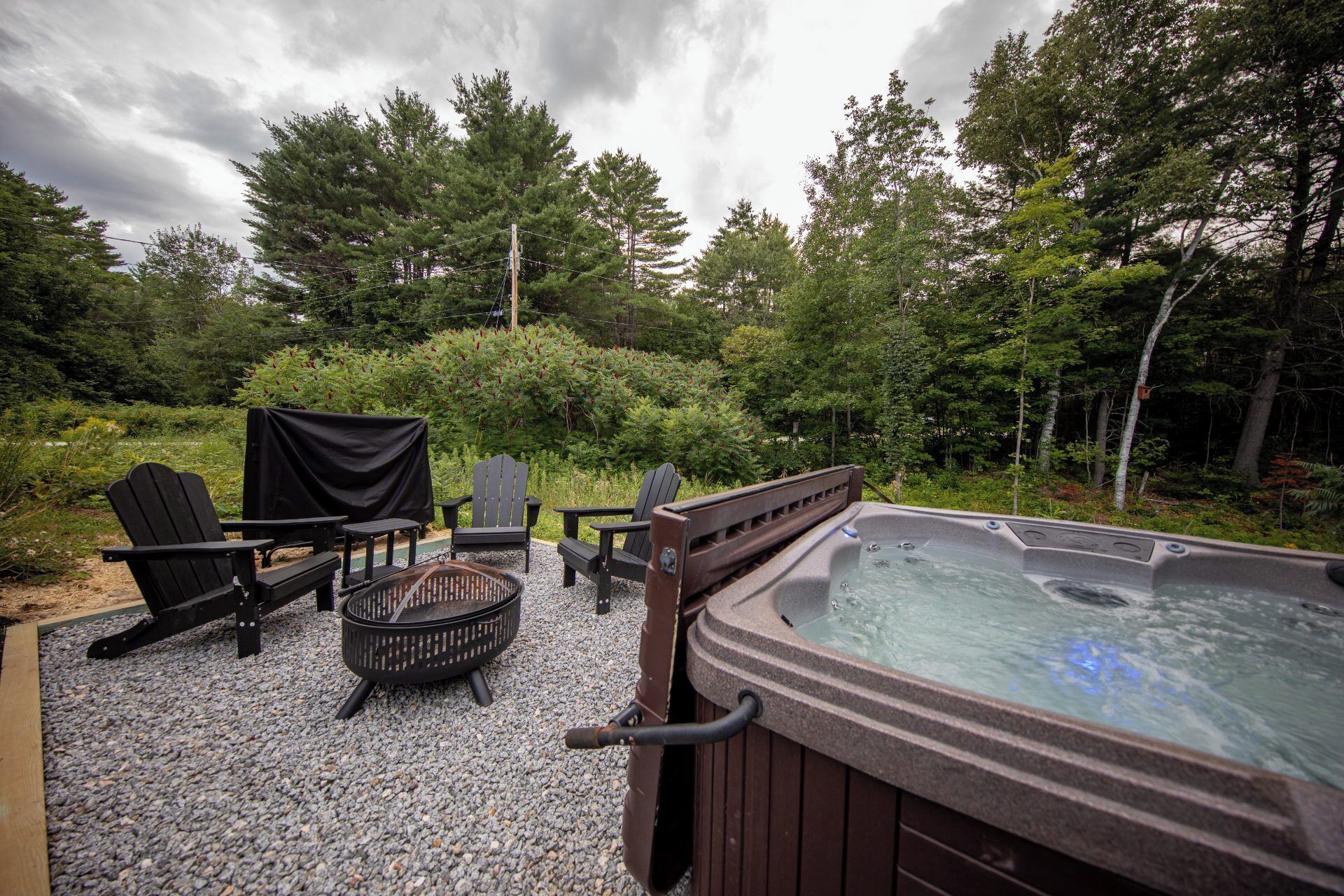 An outdoor hot tub area with seating and a fire pit.