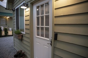 A house exterior with a white front door, a window with a view, and a mailbox.