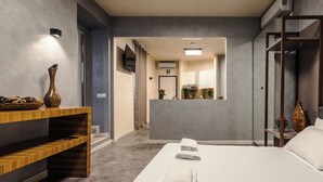 A modern hotel room with a bed, a vanity with a mirror, a wooden console table, and a wall-mounted TV. - Termini Jacuzzi Suite (Roma)
