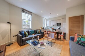 Eine moderne Wohnung mit Wohnzimmer, Küche und Essbereich.