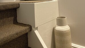 A carpeted staircase with a white handrail and a white wall.