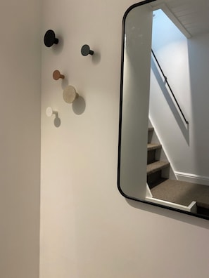 Pared con un espejo que refleja una escalera.