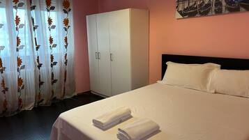 Ein Hotelzimmer mit einem Bett, einem Kleiderschrank und einem Gemälde an der Wand.