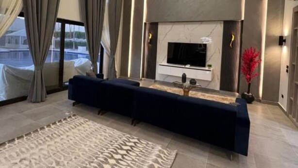 Ein modernes Wohnzimmer mit einem großen Sofa, einem Kamin und einem Fernseher.