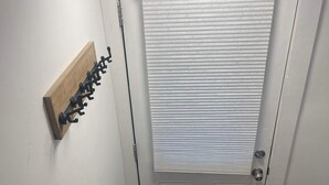 A white door with a window, a wooden coat rack, and a dark mat at the entrance. - Room to Stay in Niagara Falls (Niagara Falls)