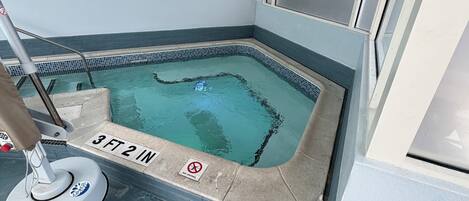 Une petite piscine intérieure dont la profondeur est indiquée par le chiffre « 3 pieds 2 pouces » et sur laquelle est affiché un panneau indiquant qu’il est interdit de se baigner.