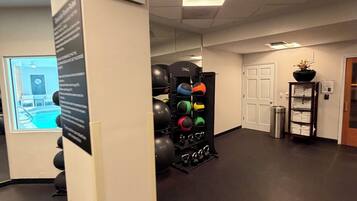 Una palestra con attrezzature per esercizi, un orologio e una porta.