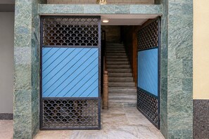 A staircase with a patterned metal gate and a blue-tiled wall. - Classic Shree Ram Residency (Cuttack)