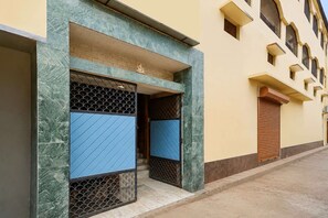 A building with a blue door and a statue above it.