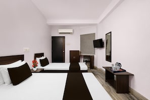 A hotel room with two beds, a desk, a chair, a TV, and an air conditioning unit. - Classic Shree Ram Residency (Cuttack)