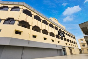 A hotel with a flat facade, multiple windows, and a sign indicating it is a hotel.