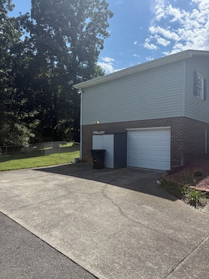 A two-story house with a garage, a fenced yard, and a driveway.