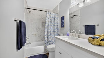 Une salle de bain moderne avec une baignoire, des toilettes et un grand miroir.