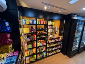 A snack aisle with various packaged goods and a self-service beverage dispenser.