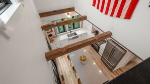 Una cucina moderna con un'isola centrale, travi in legno e vista sull'esterno.