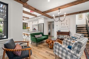 A modern living room with a green sofa, plaid sofas, and a wooden coffee table. - Coastal Retreat in the Heart of Rockport: Walk to Beaches & Bearskin Neck (Rockport)
