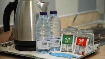 A tray with a kettle, water bottles, and two containers labeled '999'.