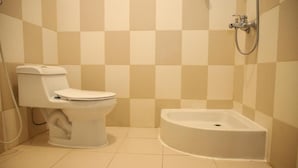 A bathroom with a toilet, a shower, and a bathtub.