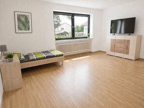 A modern room with a bed, a TV, and a cabinet. - Greengarden Apartment for Construction Workers (Vilsheim)