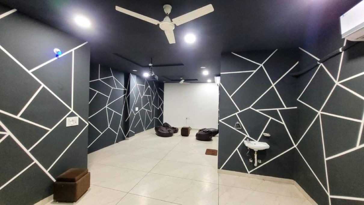 Een modern interieur met geometrische wandmotieven, een plafondventilator en een betegelde vloer.