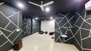 A modern interior with geometric wall patterns, a ceiling fan, and a tiled floor.