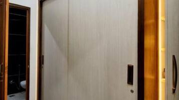 A room with a sliding door, a tiled floor, and a wall with a recessed lighting feature.