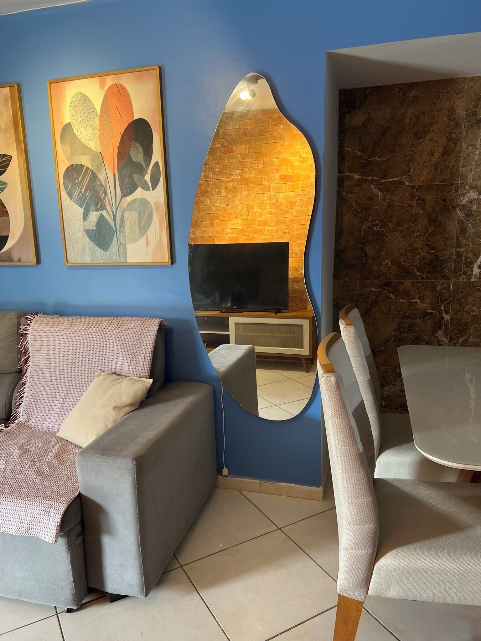 Un salon comprenant un canapé, un téléviseur, une cheminée et un coin repas avec des chaises.