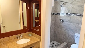 A bathroom with a sink, mirror, shower, and toilet. - LISA MOTEL (Lake Worth Beach)